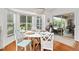 Charming dining area featuring a round table, wood floors, and serene views of the outdoors at 219 Carrera Dr, The Villages, FL 32159