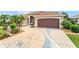 Unique driveway design leading to a charming home with lush landscaping at 219 Carrera Dr, The Villages, FL 32159