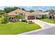 Well-maintained single-story home boasting lush green lawn, colorful landscaping, and a decorative driveway at 219 Carrera Dr, The Villages, FL 32159
