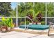 Backyard hot tub surrounded by lush landscaping and a screened enclosure at 219 Carrera Dr, The Villages, FL 32159
