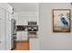 Bright white kitchen featuring stainless steel appliances, granite countertops, and hardwood floors at 219 Carrera Dr, The Villages, FL 32159