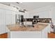Spacious kitchen with granite countertops, stainless steel appliances, and ample white cabinetry at 219 Carrera Dr, The Villages, FL 32159
