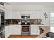 Well-appointed kitchen featuring stainless steel appliances, white cabinets, and granite countertops at 219 Carrera Dr, The Villages, FL 32159