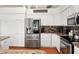 Modern kitchen featuring stainless steel appliances, white cabinets, and stylish granite countertops at 219 Carrera Dr, The Villages, FL 32159