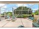 Screened lanai features a dining table and chairs set, hot tub, and views of the beautifully landscaped backyard at 219 Carrera Dr, The Villages, FL 32159