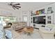 Comfortable living room with plush seating, ceiling fan, and entertainment center provides a relaxing space at 219 Carrera Dr, The Villages, FL 32159