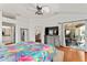 Bright main bedroom boasts wood floors, backyard access through sliding glass doors, and ensuite access at 219 Carrera Dr, The Villages, FL 32159