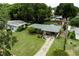Aerial view showcasing a house with an expansive lawn, driveway, and mature trees at 2202 Butler St, Leesburg, FL 34748