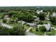 Overhead shot of houses in a green area, some with pools, near roads and businesses at 2202 Butler St, Leesburg, FL 34748
