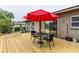 Backyard deck with a table, chairs, umbrella and sliding glass doors to the interior at 2202 Butler St, Leesburg, FL 34748