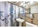 Bathroom featuring a pedestal sink, decorative shower curtain, and tiled walls at 2202 Butler St, Leesburg, FL 34748