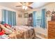 Bedroom featuring blue curtains, decorative wall hangings, and wood dresser at 2202 Butler St, Leesburg, FL 34748