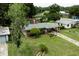 A well-maintained single-story house with a neatly landscaped front yard, carport, and a cozy front porch at 2202 Butler St, Leesburg, FL 34748