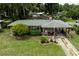 Charming single-story home with a covered carport, mature landscaping, and a well-maintained front lawn at 2202 Butler St, Leesburg, FL 34748