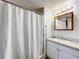 Bathroom featuring a shower with curtain, white vanity with integrated sink, and mirror with lighting at 239 Rue De Fontaine, Tavares, FL 32778