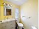 Bright bathroom featuring updated vanity, mirror, and toilet with a small window offering natural light at 239 Rue De Fontaine, Tavares, FL 32778