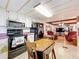 Functional kitchen with white cabinets, black appliances, and a dining area seamlessly connected to the living room at 239 Rue De Fontaine, Tavares, FL 32778