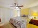 Inviting main bedroom featuring a ceiling fan, bedside tables with lamps, and bright natural light at 239 Rue De Fontaine, Tavares, FL 32778