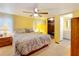 Relaxing main bedroom with a large bed, ceiling fan, and access to the en-suite bathroom, a cozy sanctuary at 239 Rue De Fontaine, Tavares, FL 32778