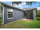 Features gray siding, a screened patio with a door, a large window, and a well-maintained lawn at 2448 Bachman Path, The Villages, FL 32162