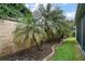 Landscaped backyard featuring tropical plants and a brick-lined garden, offering a serene and private outdoor space at 2448 Bachman Path, The Villages, FL 32162