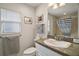Bathroom showcasing a granite countertop, framed mirror, and a shower with a striped curtain at 2448 Bachman Path, The Villages, FL 32162