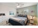 Bright bedroom with updated floors, furniture, and a ceiling fan allows for comfortable living at 2448 Bachman Path, The Villages, FL 32162