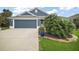 Charming single-story home with a well-manicured lawn, dark gray siding, and a two car garage at 2448 Bachman Path, The Villages, FL 32162