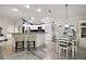 Bright and open kitchen features white cabinetry, granite countertops, a breakfast bar, and a cozy dining area at 2448 Bachman Path, The Villages, FL 32162
