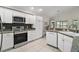 Bright kitchen with white cabinets, granite countertops, and stainless steel appliances, perfect for cooking and entertaining at 2448 Bachman Path, The Villages, FL 32162