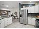 Spacious kitchen featuring stainless steel refrigerator, granite countertops, and open access to the living area at 2448 Bachman Path, The Villages, FL 32162