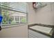 Functional laundry area with sink, window and storage space at 2448 Bachman Path, The Villages, FL 32162