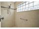 Modern shower features a glass block window, tiled walls, and a shower niche for storage at 2448 Bachman Path, The Villages, FL 32162