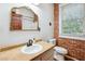 Bathroom with an ornate mirror, stylish sink, exposed brick, and a window at 263 Ne 1St St, Webster, FL 33597