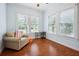 Cozy bedroom featuring hardwood floors, bright windows, and a comfortable armchair at 263 Ne 1St St, Webster, FL 33597