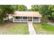 Charming home featuring a metal roof, inviting front porch, and well-maintained lawn at 263 Ne 1St St, Webster, FL 33597