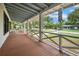 A wide front porch with wooden deck and view to the street and lush greenery at 263 Ne 1St St, Webster, FL 33597