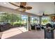 Inviting screened lanai featuring comfortable seating, ceiling fans, and a serene outdoor view at 26601 Otter Creek Ln, Leesburg, FL 34748