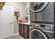 Functional laundry room featuring a stacked washer and dryer, counter space, and storage cabinets at 26601 Otter Creek Ln, Leesburg, FL 34748