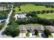 Aerial view of charming townhomes with lush landscaping, manicured lawns, and a large green field nearby at 26917 White Plains Way, Leesburg, FL 34748