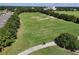 Aerial shot of a community driving range and golf course surrounded by trees and lovely scenery at 26917 White Plains Way, Leesburg, FL 34748