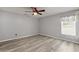 Clean bedroom with ceiling fan, light gray walls and floors with window at 26917 White Plains Way, Leesburg, FL 34748