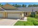 Charming home exterior with a two-car garage, well-maintained lawn, and an American flag at 26917 White Plains Way, Leesburg, FL 34748