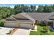 Well-maintained home featuring a two-car garage and lush landscaping at 26917 White Plains Way, Leesburg, FL 34748