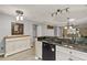 Stylish kitchen with granite countertops, white cabinetry, and views of the living room at 26917 White Plains Way, Leesburg, FL 34748