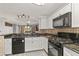 Modern kitchen featuring sleek black appliances, granite countertops, and stylish tile backsplash at 26917 White Plains Way, Leesburg, FL 34748