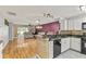 Modern kitchen featuring granite countertops, sleek appliances, and open floor plan to living room at 26917 White Plains Way, Leesburg, FL 34748