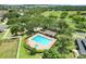 Aerial view of a large pool with a spa, surrounded by trees and landscaping in the neighborhood at 2745 Shearwater St, Clermont, FL 34711