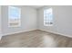 Bright bedroom featuring two windows and light wood-look flooring at 2745 Shearwater St, Clermont, FL 34711
