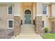 Elegant front entrance with a decorative door, stone pillars, and manicured landscaping at 2745 Shearwater St, Clermont, FL 34711